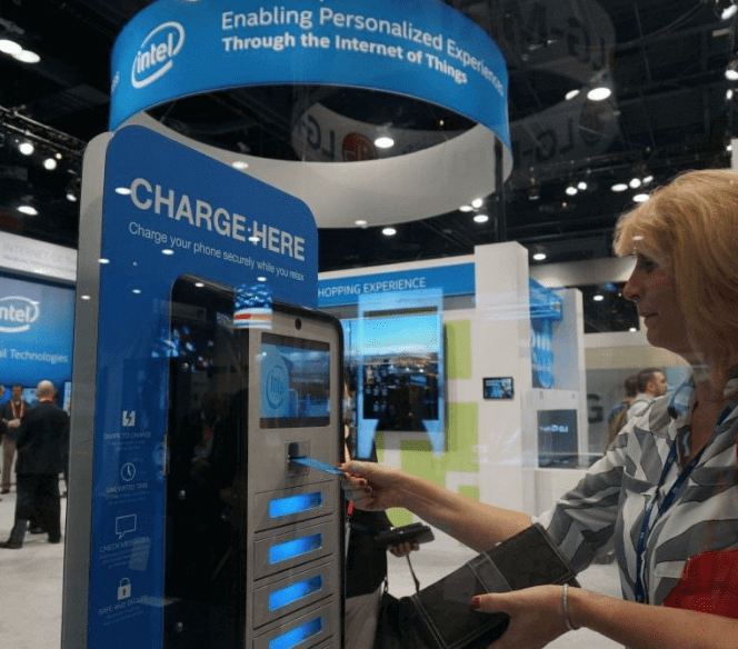 Woman inserting credit card into locker charging station at trade show convention